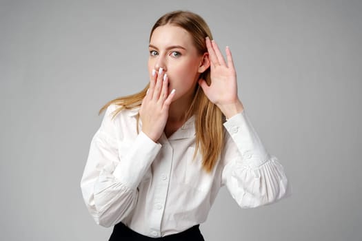 Young Woman in White Shirt Listening With Hand to Ear