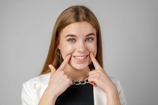 Woman Holding Finger to Smile in Studio close up