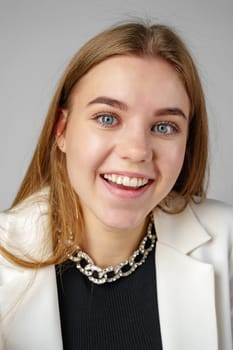 Woman in Black Top and White Jacket Posing in Studio close up