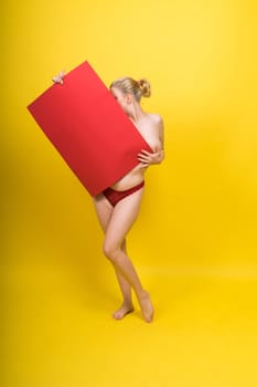 Blonde model, Young woman holding a cardboard cloud red sheet of papaer, place for an inscription