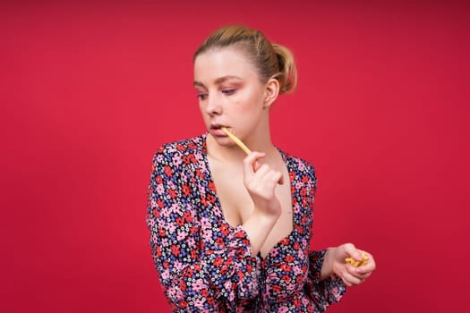 Unhealthy eating. Junk food concept. Portrait of a fashionable young woman holding fried potato