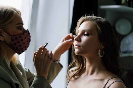 Make-up artist work in the studio with model