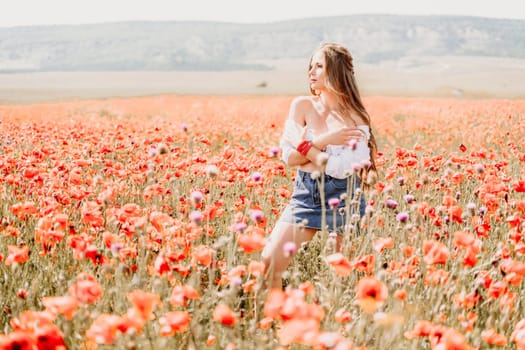 Woman poppies field. Side view of a happy woman with long hair in a poppy field and enjoying the beauty of nature in a warm summer day