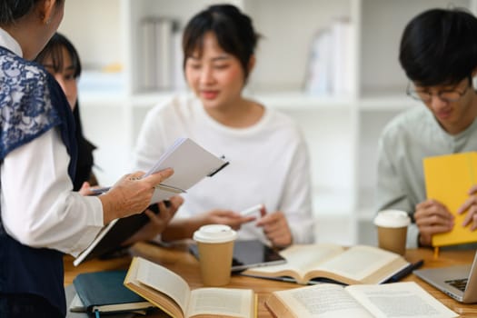 Cropped shot of middle age professor explaining lesson to students during a class.