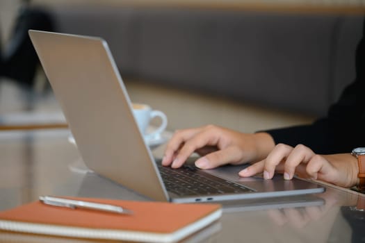 Businesswoman sitting in office and typing on laptop for planning online research.