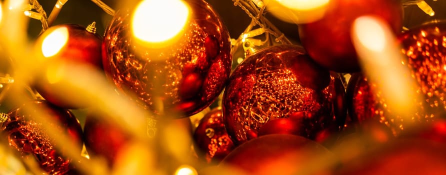 Close up of red Christmas balls baubles. Bokeh garlands. Xmas and holidays concept. Copy space and empty place for text, mock up greeting card.