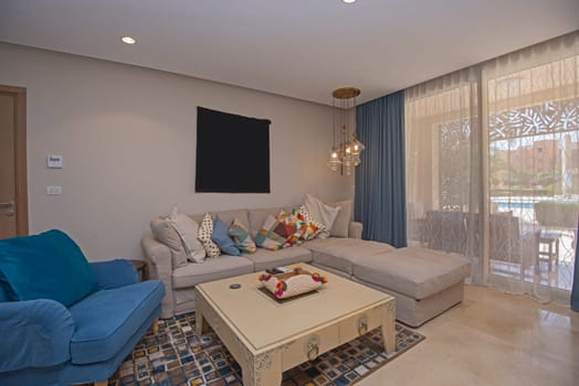 Living room lounge area in luxury apartment show home showing interior design decor furnishing with patio terrace