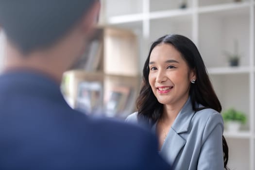 A young businessman and a female Asian accountant are discussing financial accounting and business planning together in the office..