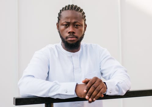 Cheerful male tourist portrait dress in white wear dashiki ethnic smiling at city street or small town background. African American travel model have free time. Millennial generation and gen z people.