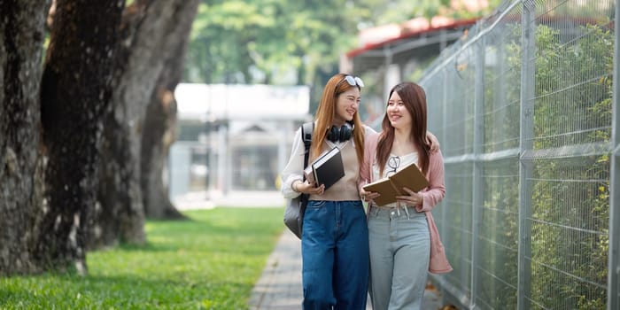 University student girl friends with learning book college while walking in campus.