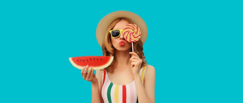 Summer portrait of happy young woman with fresh juicy fruits, lollipop and slice of watermelon wearing straw hat, sunglasses on blue background