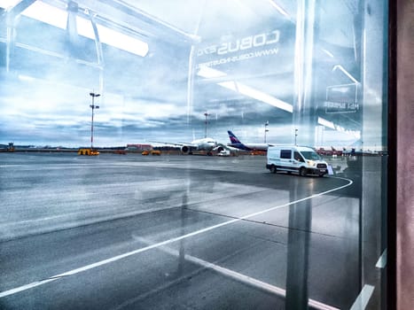 Moscow, Russia - April 04, 2024: planes at the airport, view through the window. Planes awaiting departure at dawn seen from an airplane window