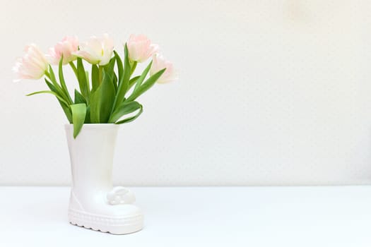 bouquet of tulips in Easter bunny vase on white table. copy space