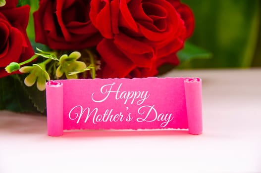 Happy mother's day text on pink paper with roses background.