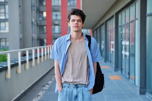 Portrait of confident smiling college student guy, young male with backpack looking at camera, urban outdoor. Education, lifestyle, 19,20 years age youth concept