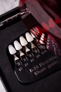 a scale for checking the color of teeth in close-up. Cosmetic dentistry.