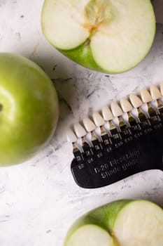 Color scale of teeth cosmetic dentistry. Scale and green apples top view.