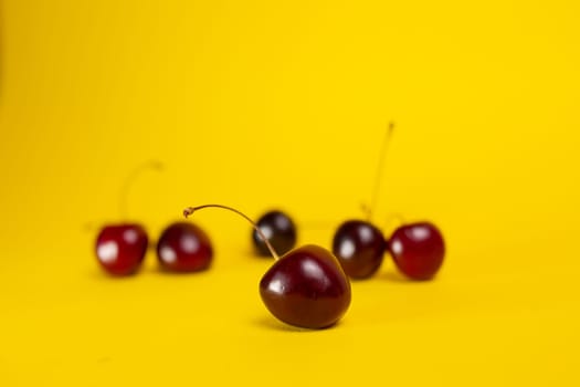 ripe cherries close-up on a yellow background.