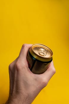 tin can in a man's hand on a yellow background.