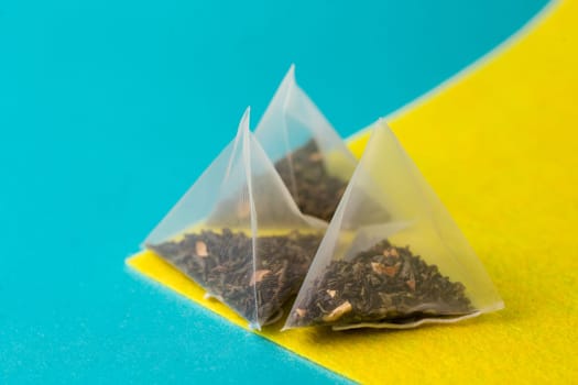 green tea in a pyramid bag on a yellow blue background.