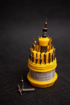 a set of yellow screwdrivers on a black background.