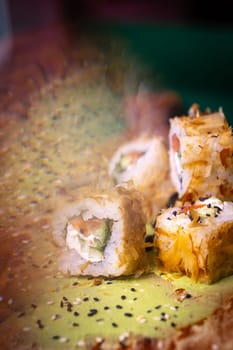 Delectable deep-fried sushi roll with fresh salmon, cucumber, on wooden plate with wasabi and sesame seeds, a Japanese delight.