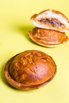 closed burgers in a bun with juicy filling on a yellow background.