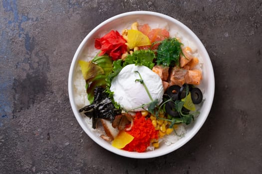 A delicious and healthy poke bowl filled with fresh salmon, a soft-boiled egg, and an assortment of colorful vegetables.