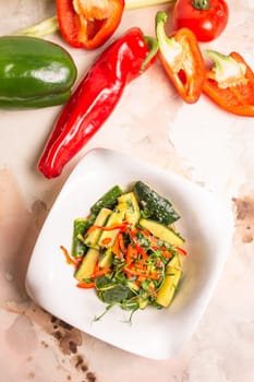 Garnish of fresh cucumbers, bell peppers, and herbs on a white plate on a solid pink background. Isolated. Healthy eating concept.