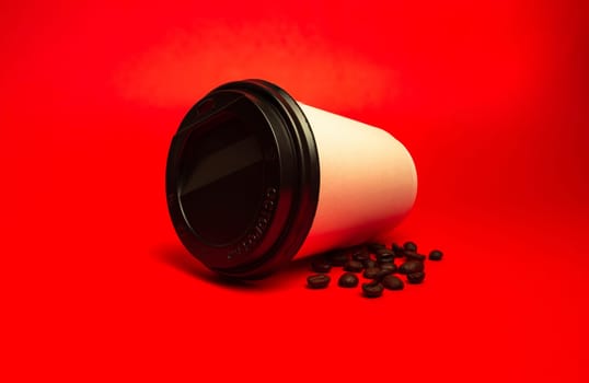 white paper cup with coffee beans on a red background.