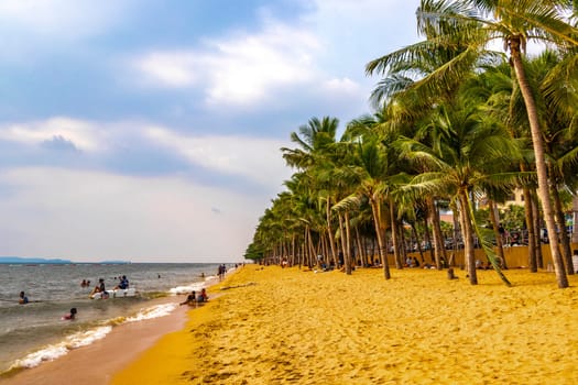 Pattaya Chon Buri Thailand 25. October 2018 Tropical beach waves water sand people boat palm trees and skyscrapers in Jomtien Beach Pattaya Bang Lamung Chon Buri Thailand in Southeastasia Asia.