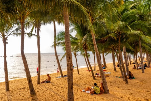 Pattaya Chon Buri Thailand 25. October 2018 Tropical beach waves water sand people boat palm trees and skyscrapers in Jomtien Beach Pattaya Bang Lamung Chon Buri Thailand in Southeastasia Asia.