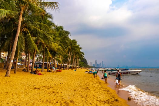 Pattaya Chon Buri Thailand 25. October 2018 Tropical beach waves water sand people boat palm trees and skyscrapers in Jomtien Beach Pattaya Bang Lamung Chon Buri Thailand in Southeastasia Asia.