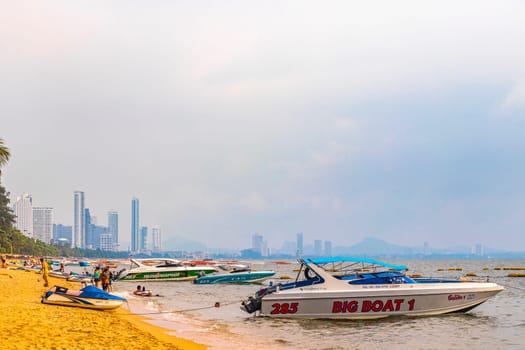 Pattaya Chon Buri Thailand 25. October 2018 Tropical beach waves water sand people boat palm trees and skyscrapers in Jomtien Beach Pattaya Bang Lamung Chon Buri Thailand in Southeastasia Asia.