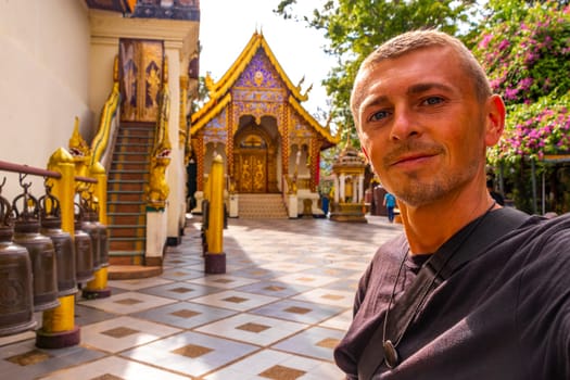 Handsome man male tourist at golden gold Wat Phra That Doi Suthep temple temples building in Chiang Mai Amphoe Mueang Chiang Mai Thailand in Southeastasia Asia.