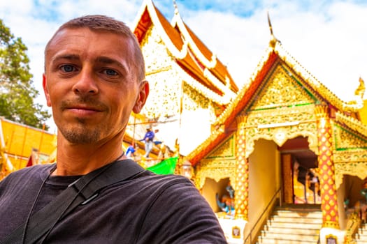 Handsome man male tourist at golden gold Wat Phra That Doi Suthep temple temples building in Chiang Mai Amphoe Mueang Chiang Mai Thailand in Southeastasia Asia.