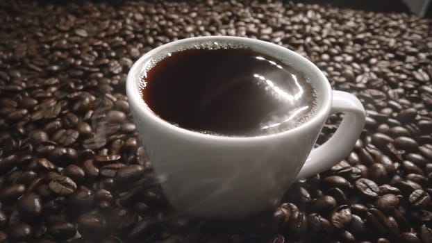 Top view of coffee or espresso with piles of coffee beans. Close up of fresh roasted coffee bean scatter around wooden table with cup of americano and aromatic stream and smoke from seed. Comestible.