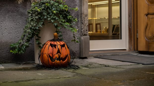 Exterior Beautiful atmospheric halloween scary grin drawn pumpkins decorated on porch. Autumn leaves and fall flowers celebration holiday Thanksgiving October season outdoors in city