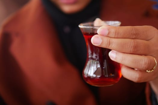 woman drinking Traditional turkish tea on white table