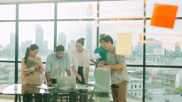 Group of diverse business people brainstorming about marketing plan. Multicultural business team working, talking, presenting about financial strategy with idea written on glass wall. Tracery