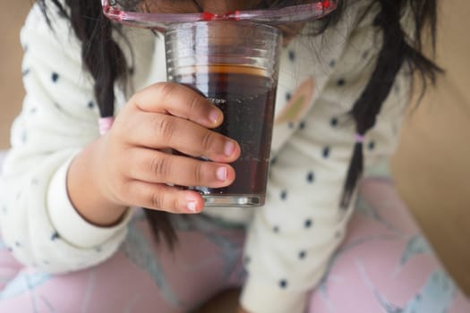 child drinking glass of soft drinks .