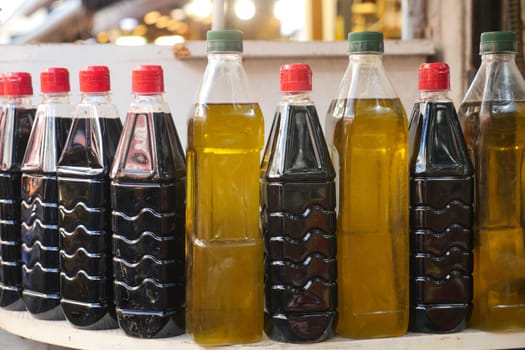 Several bottles of oil arranged on a table for food storage.
