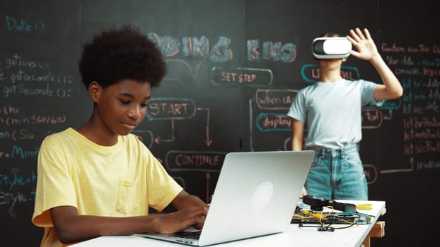 Smart african student programing and coding innovative system while caucasian girl enter in metaverse or virtual world by using VR or head set at blackboard in STEM technology classroom. Edification.