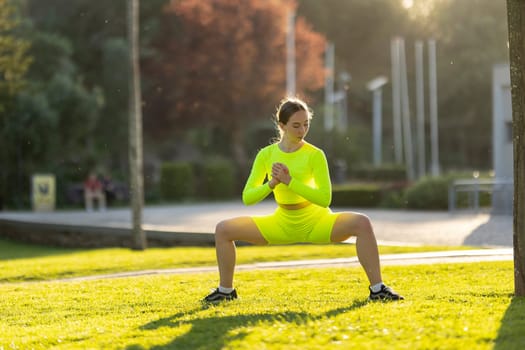 A woman in a neon yellow outfit is doing a yoga pose in a park. The scene is bright and cheerful, with the sun shining down on the grass and the woman. The woman's pose is focused and determined