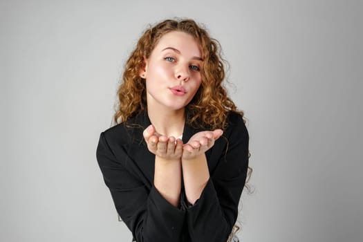 Young Woman Blowing a Kiss Towards the Camera in a Studio Setting close up