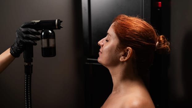 Portrait of a red-haired woman undergoing an instant tanning procedure