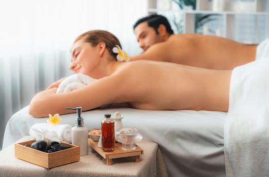 Aromatherapy massage on daylight ambiance or spa salon composition setup with focus decor and spa accessories on blur woman enjoying blissful aroma spa massage in resort or hotel background. Quiescent