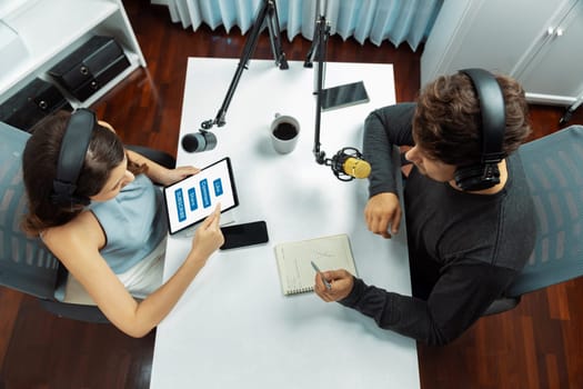 Top view of host channel broadcasters wearing headsets talking show on live streaming with listeners surround set of live stream mic on social media recording radio at modern studio office. Postulate.