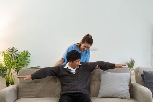 elderly Asian man physical therapy with support of nurse or caregiver. Elderly man doing exercises for patient with caregiver in home nursing.