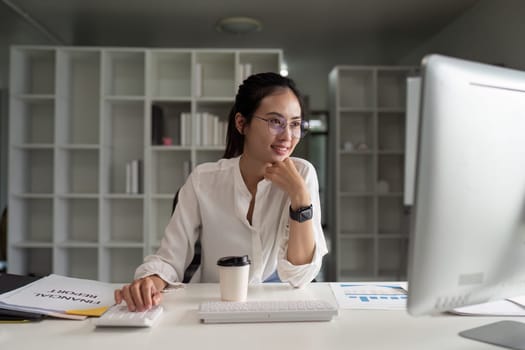 Portrait of an Asian woman working on a tablet computer in a modern office. Make an account analysis report.